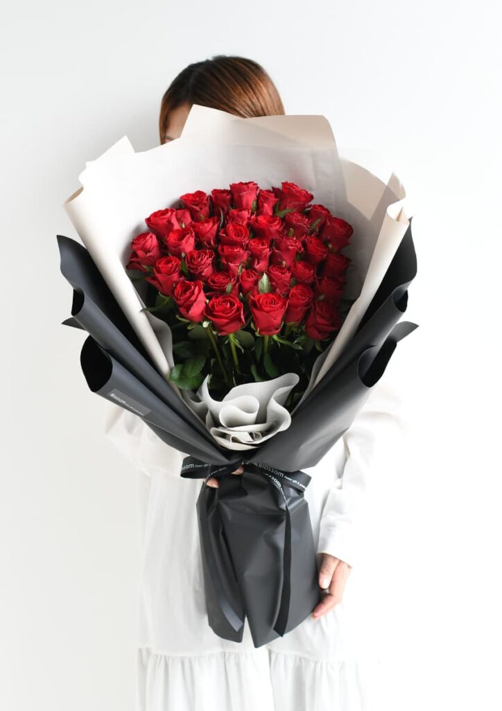 黒色のラッピングをした赤バラの花束