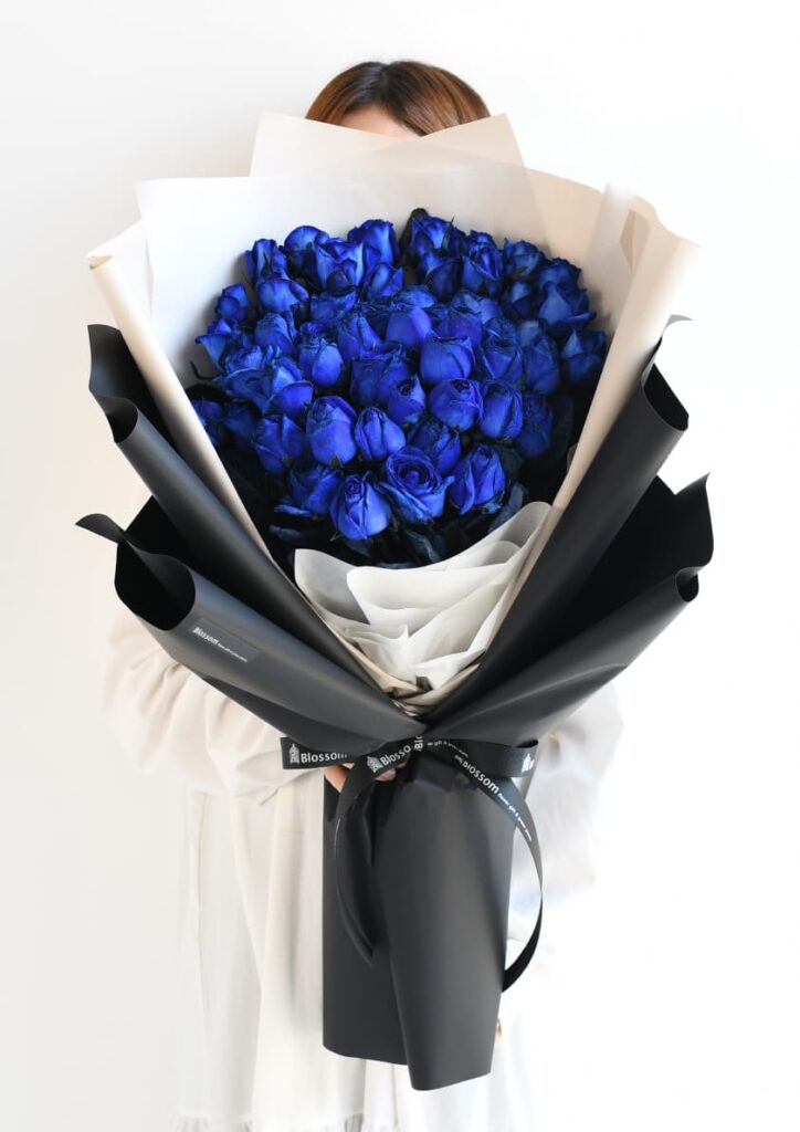 黒色のラッピングをした青いバラの花束