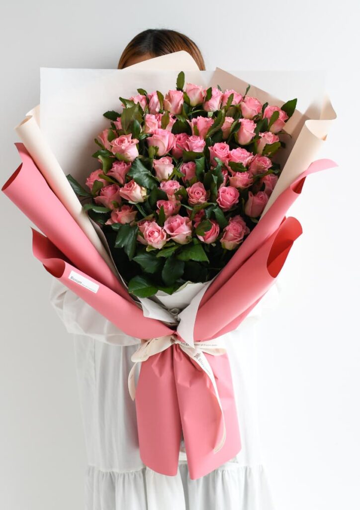 ピンク色のラッピングをしたピンクのバラの花束