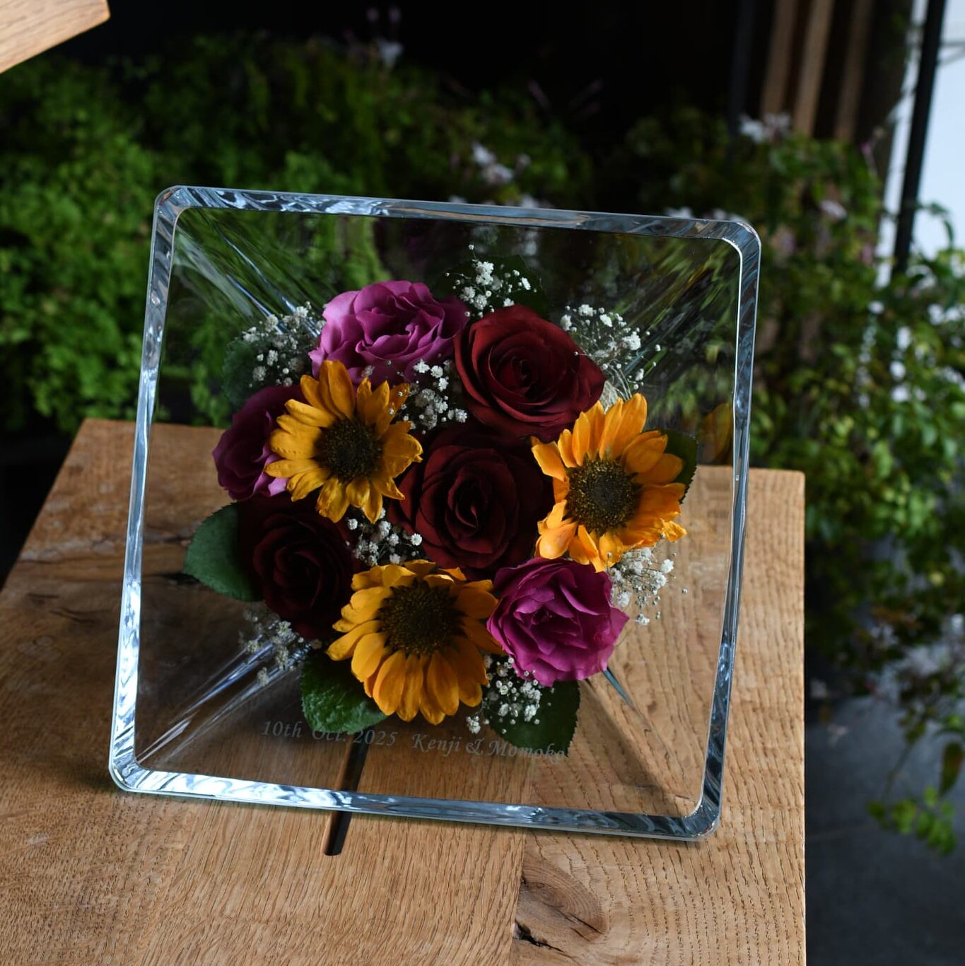 ガラスに入ったひまわりとバラの花束